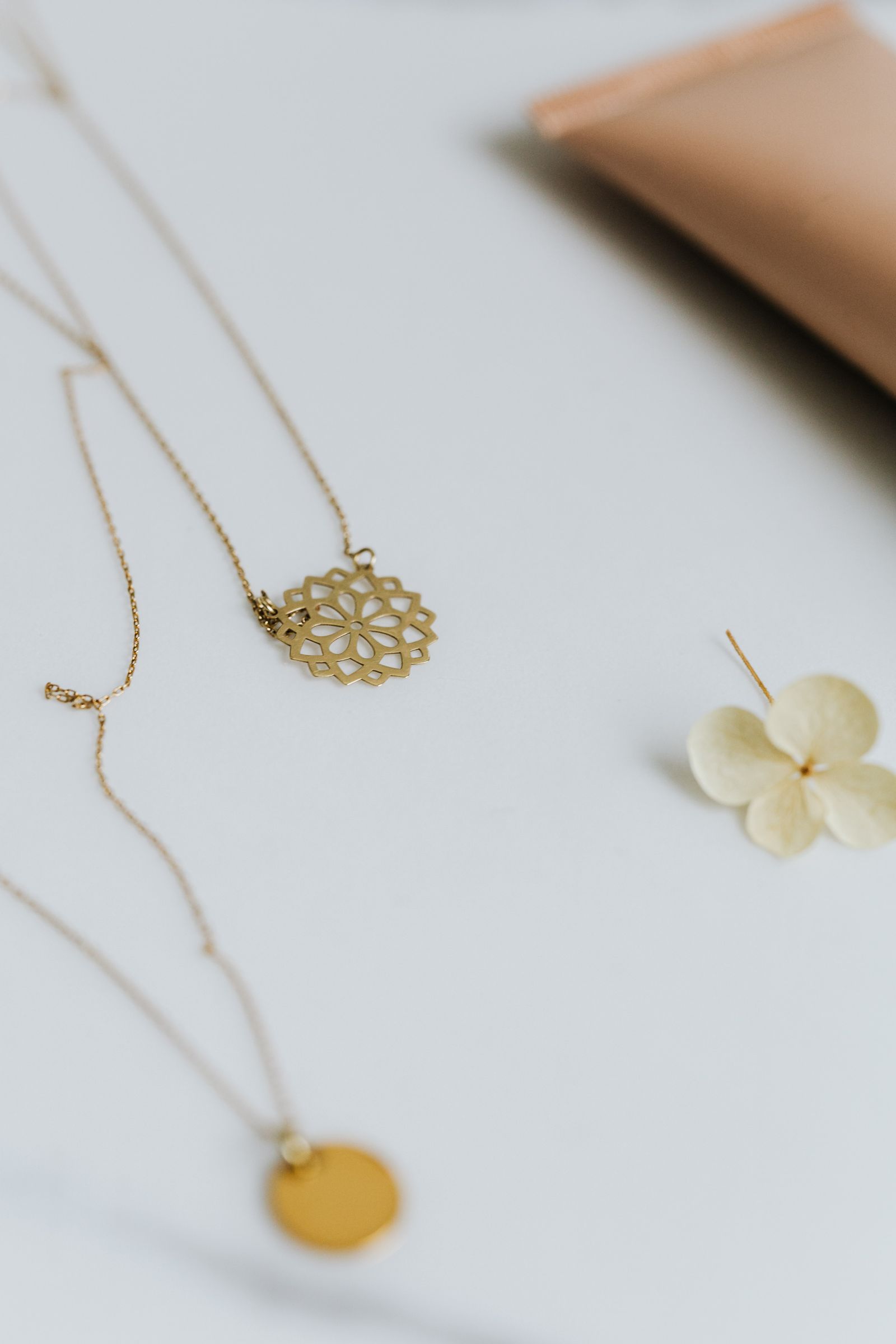 Stylish display of gold necklaces paired with floral decor, highlighting elegance and design.